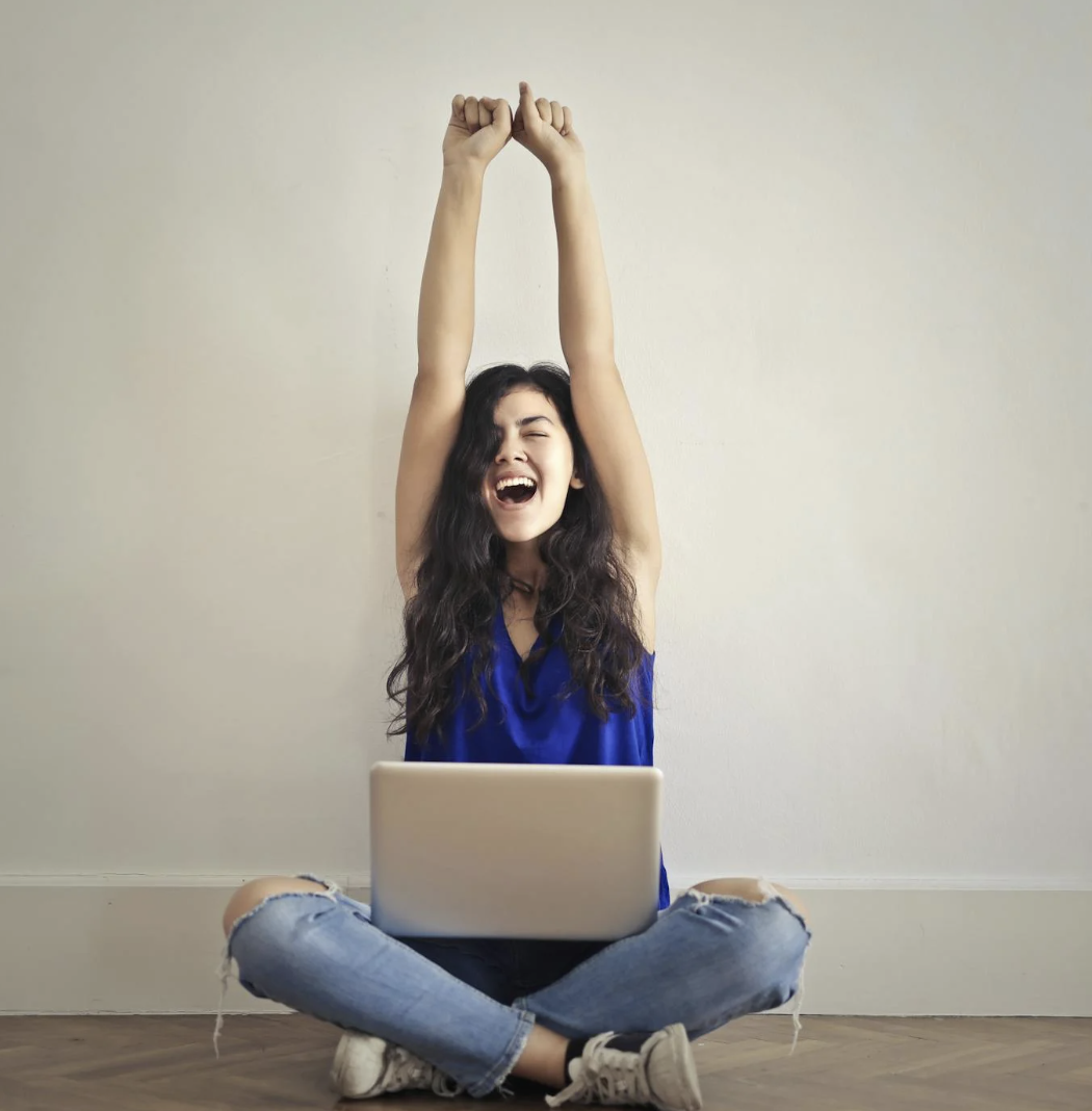 woman cheering with laptop